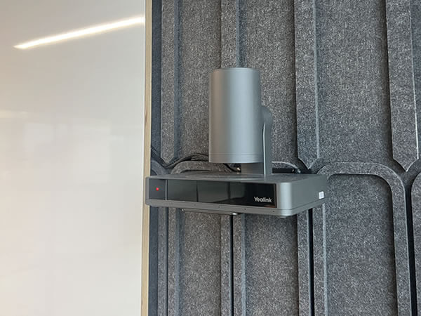 Close-up of Yealink PTZ camera mounted on acoustic wall panel as part of Synextra’s Microsoft Teams Room setup.