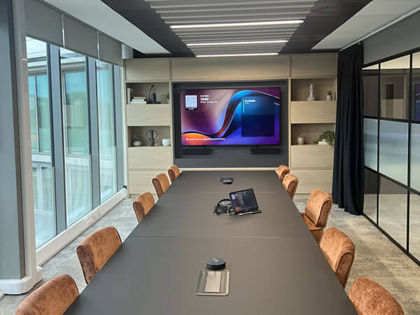 Wide shot of Synextra’s executive boardroom with large display, Teams Room technology and modern AV integration by Rapid Technologies.