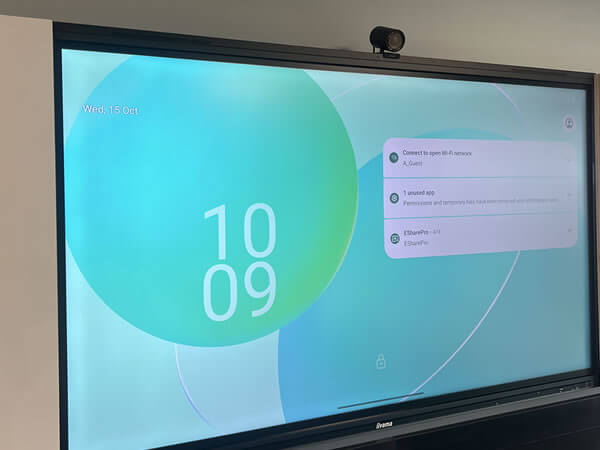 Close-up of iiyama interactive touchscreen display with camera showing digital meeting interface in Synextra’s workspace.