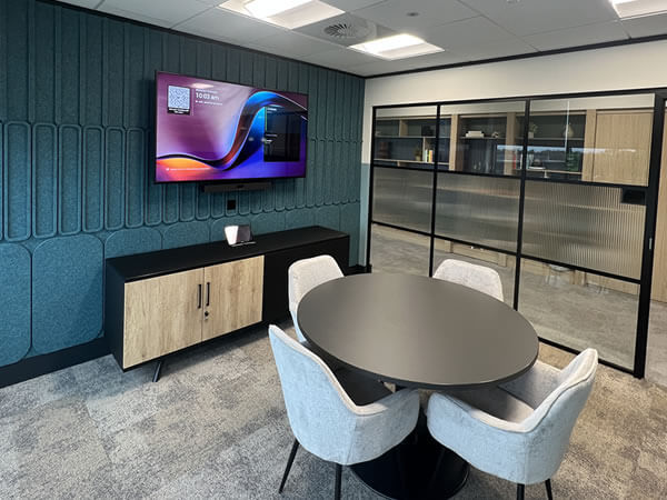 Small meeting room at Synextra fitted with Sony display, Yealink conferencing system and modern furniture for hybrid collaboration.